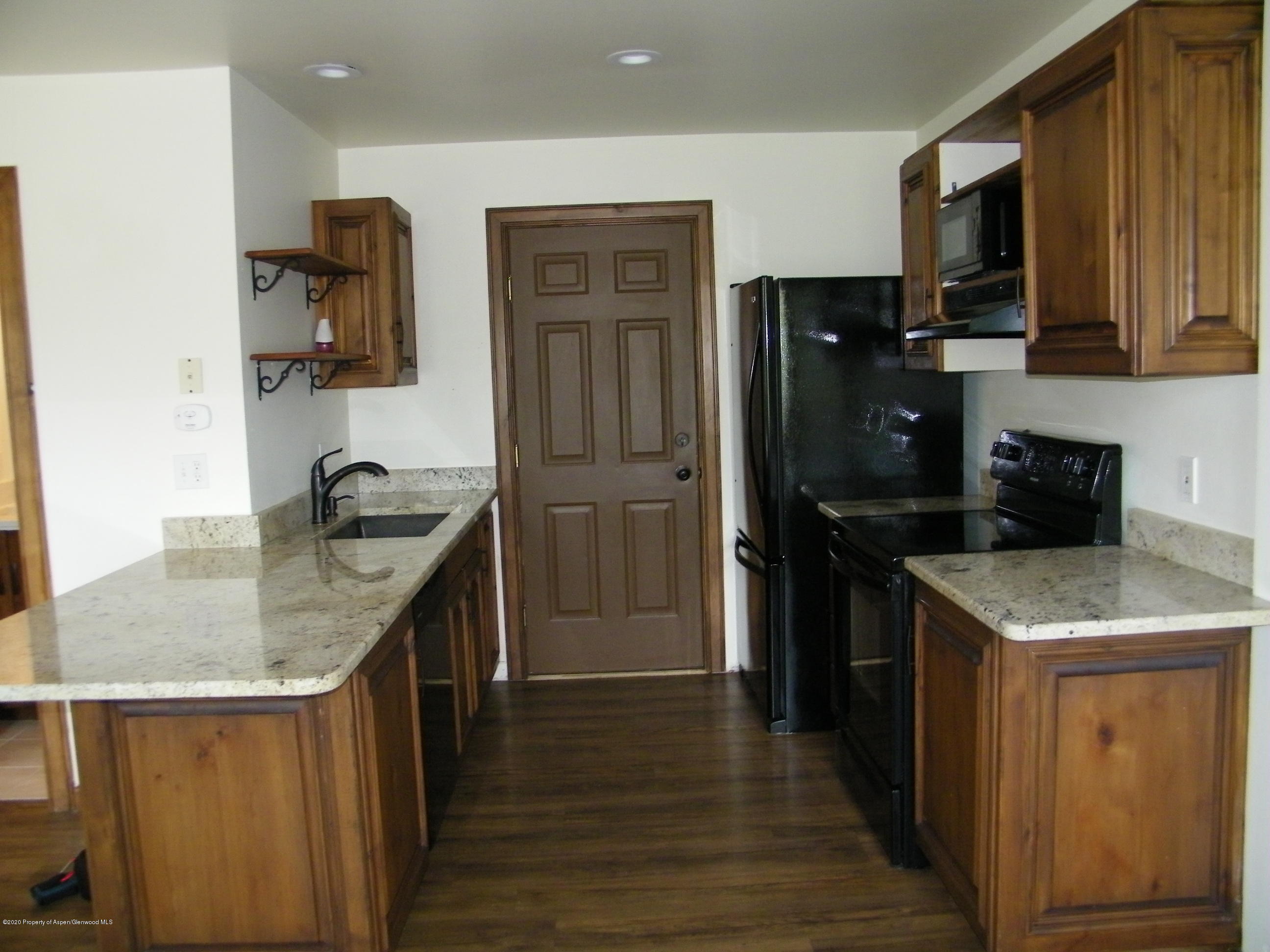 678 Alder Ridge Lane New Castle, CO 81647 - Photo 3 of 18 a kitchen with kitchen island granite countertop stainless steel appliances and wooden cabinets