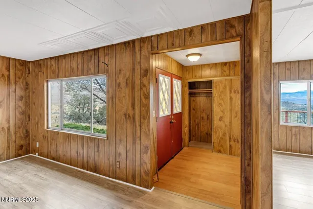 a view of hallway with a large window and wooden floor