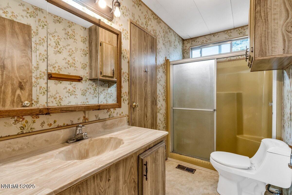 1211 Slate Road Topaz Ranch Estates, NV 89444 - Photo 26 of 30 a bathroom with a granite countertop sink toilet and shower