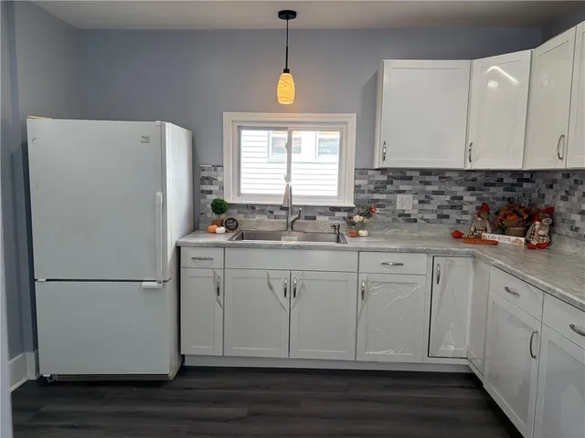 a kitchen with granite countertop white cabinets and white appliances