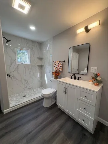 a bathroom with a double vanity sink mirror and toilet