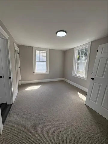 an empty room with a fireplace and windows