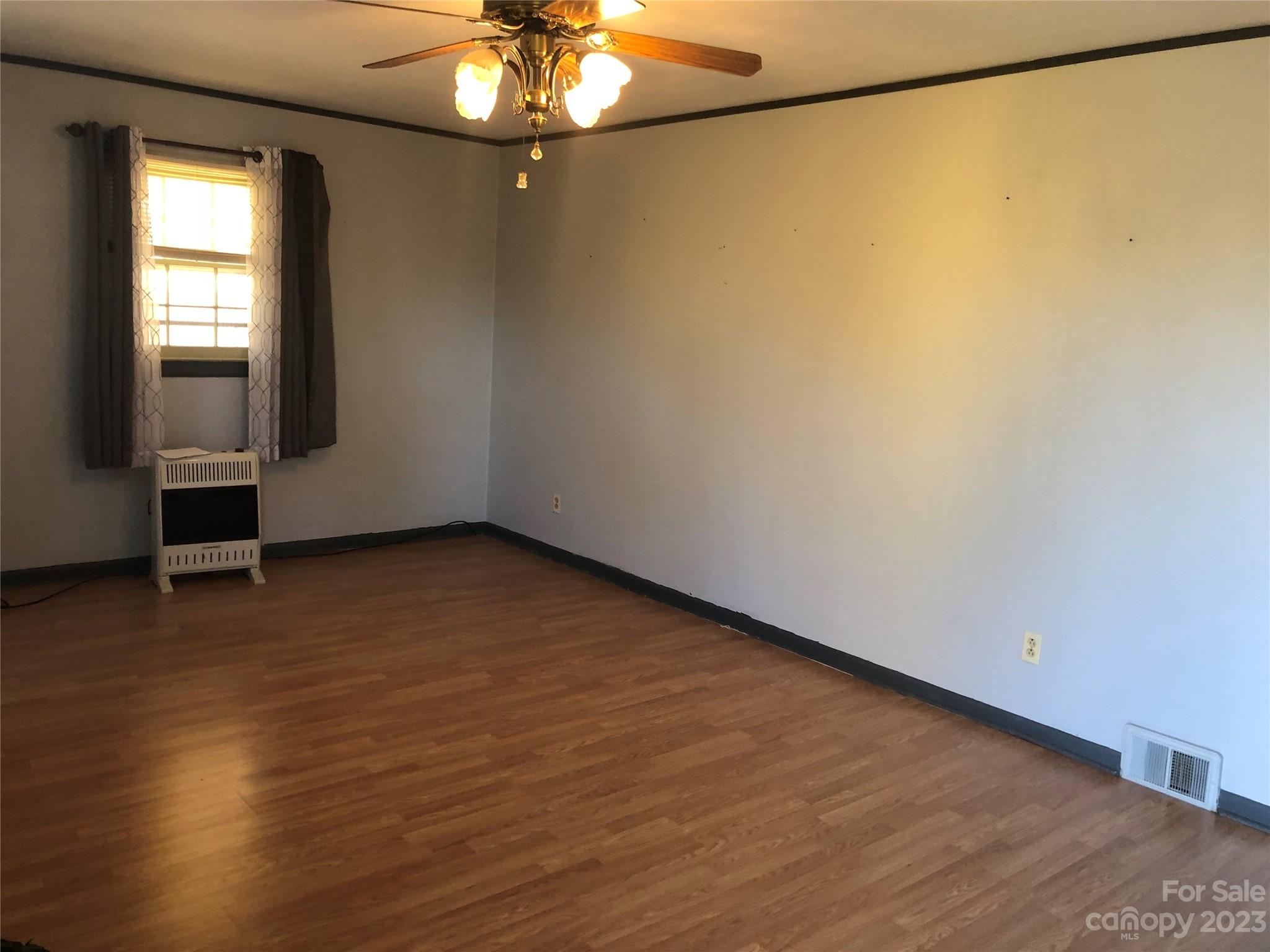 530 Shelton Road Clyde, NC 28721 - Photo 20 of 36 a view of an empty room with wooden floor and a window