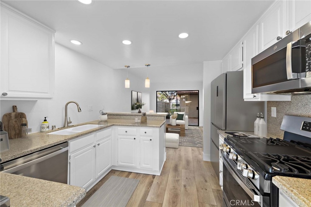 25702 Seaside Drive Dana Point, CA 92629 - Photo 16 of 37 a kitchen with stainless steel appliances a sink dishwasher a stove top oven a refrigerator with wooden floor and cabinets