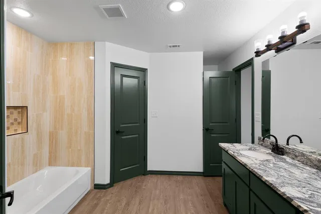 a bathroom with a granite countertop sink and a mirror