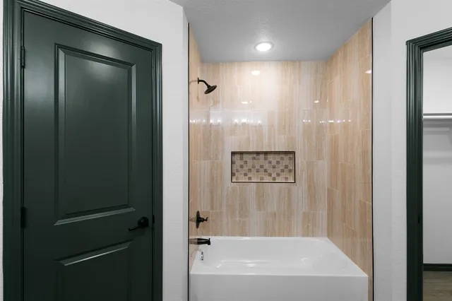 a bathroom with a shower and a bath tub