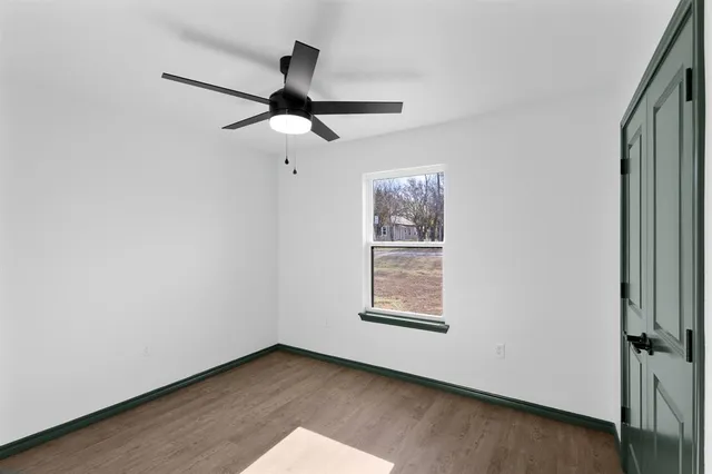 an empty room with windows and fan