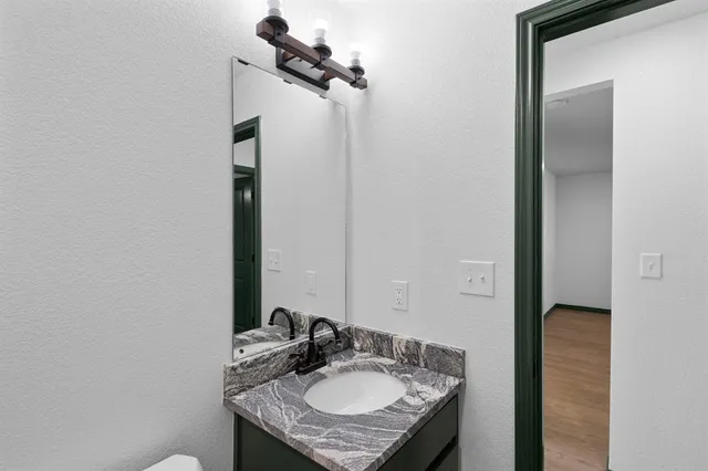 a bathroom with a granite countertop sink and a mirror