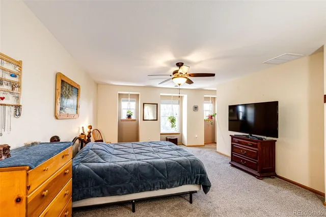 a spacious bedroom with a bed and a flat screen tv
