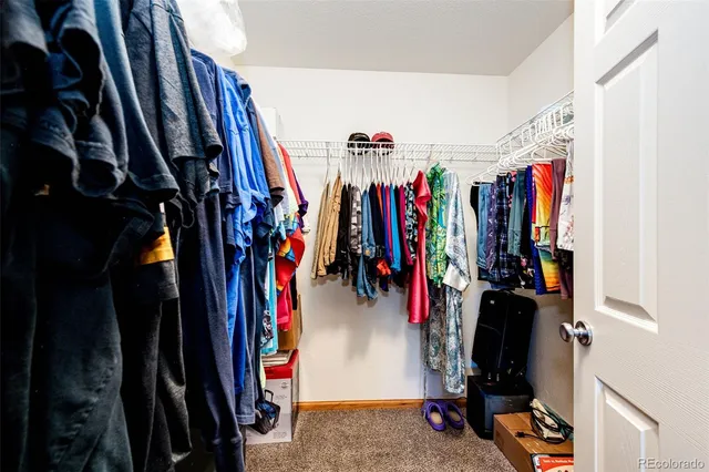 a view of walk in closet with clothes