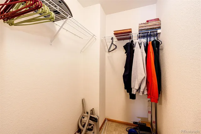 a view of walk in closet with clothes and shoes