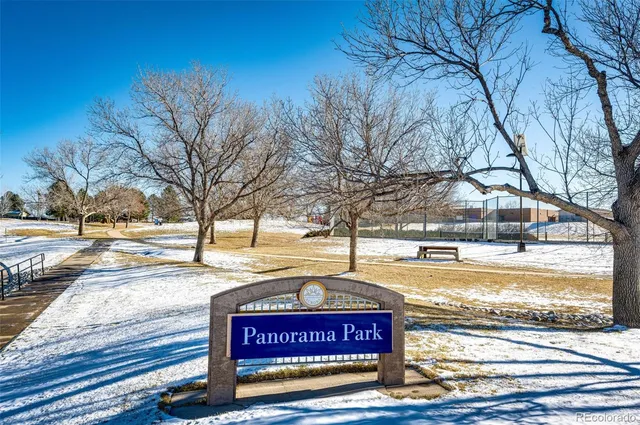a view of a yard with a bench and trees around