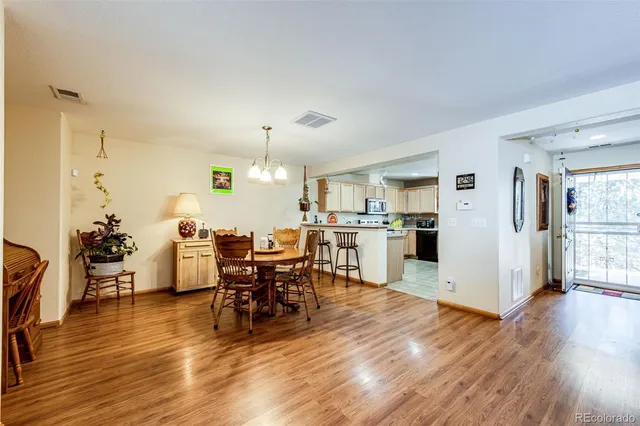 a view of a dining room and livingroom with furniture wooden floor a rug a fireplace