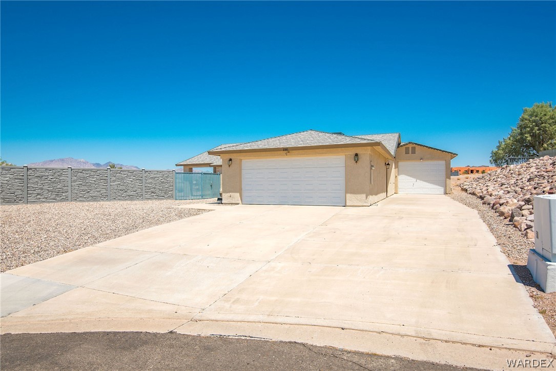 3395 Pegasus Ranch Lane Bullhead City, AZ 86429 - Photo 1 of 50 a white house with a large tree with wooden fence