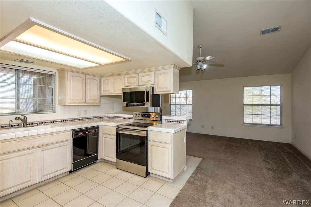 3395 Pegasus Ranch Lane Bullhead City, AZ 86429 - Photo 20 of 50 a kitchen with stainless steel appliances granite countertop a stove sink and microwave