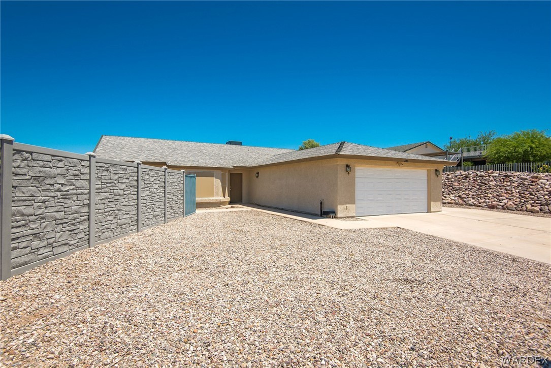3395 Pegasus Ranch Lane Bullhead City, AZ 86429 - Photo 6 of 50 a view of yellow house with a yard and large tree