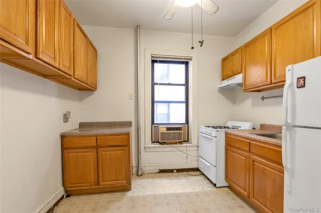 a kitchen with a refrigerator a stove top oven a sink and cabinets