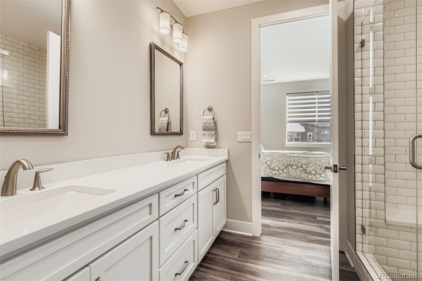 12355 West 51st Avenue Wheat Ridge, CO 80033 - Photo 11 of 17 a bathroom with double vanity sink a two mirror a window and vanity