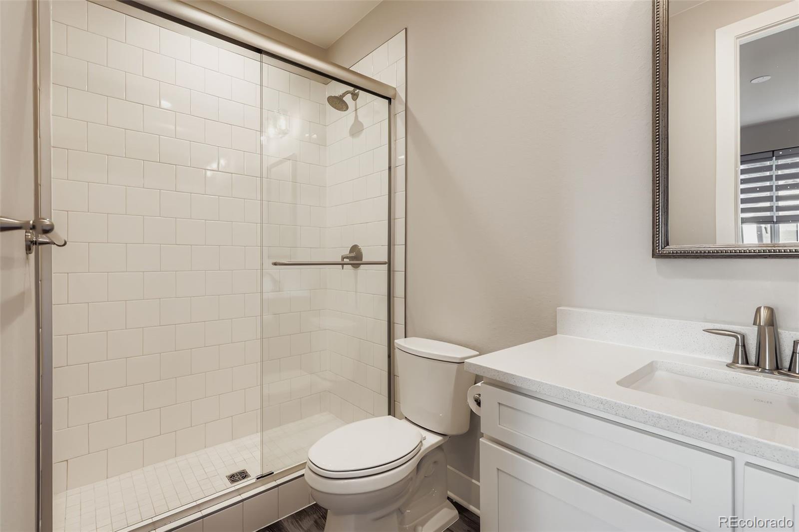 12355 West 51st Avenue Wheat Ridge, CO 80033 - Photo 13 of 17 a white toilet sitting next to a bathroom sink