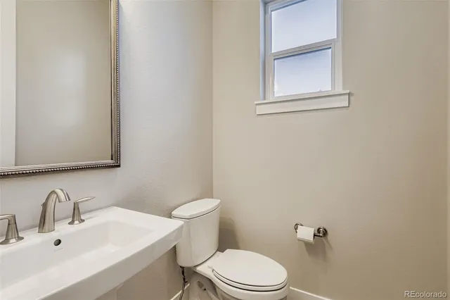 a bathroom with a sink a toilet and mirror