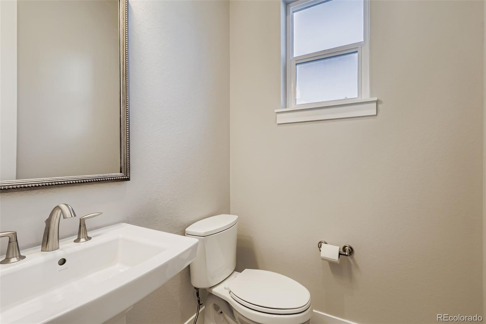 12355 West 51st Avenue Wheat Ridge, CO 80033 - Photo 9 of 17 a bathroom with a sink a toilet and mirror