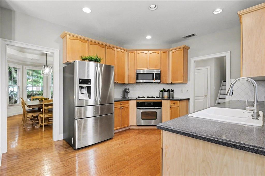 12552 Waterside Drive Alpharetta, GA 30004 - Photo 10 of 33 a kitchen with granite countertop a refrigerator a stove top oven and a sink