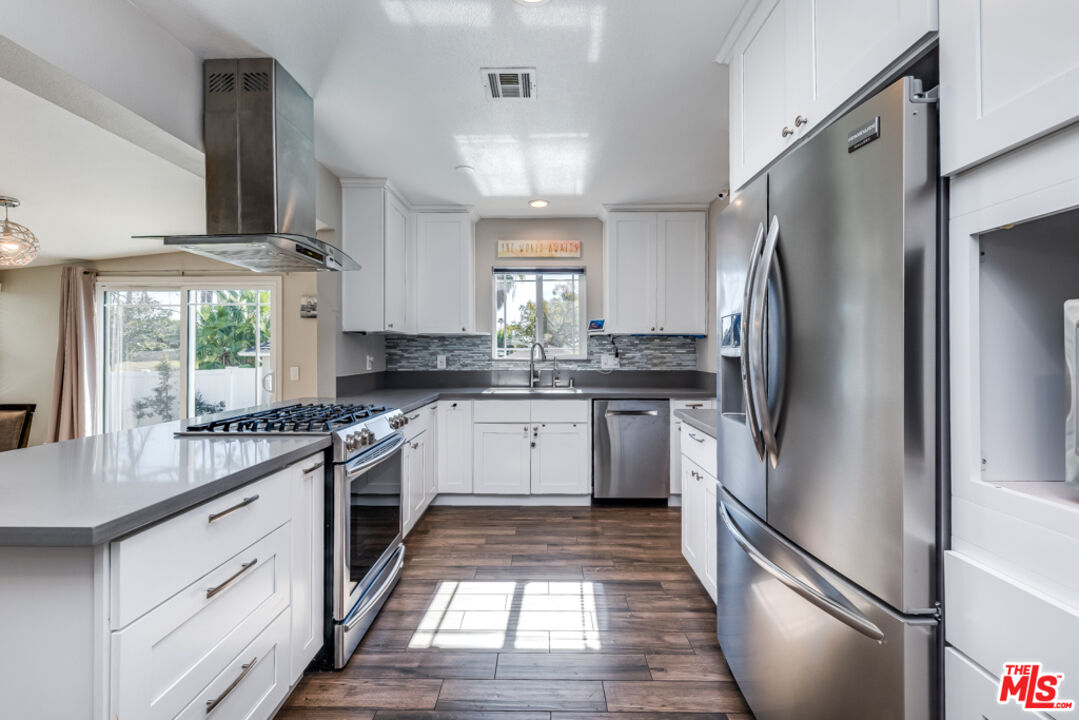 3330 Hermanos Street Pasadena, CA 91107 - Photo 11 of 40 a kitchen with stainless steel appliances a refrigerator sink and cabinets