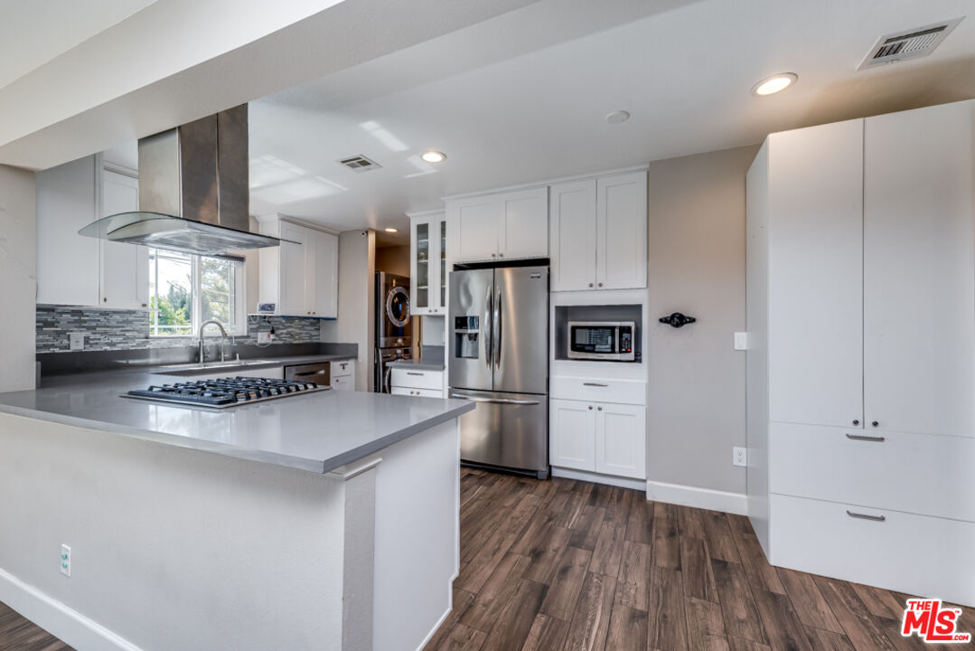 3330 Hermanos Street Pasadena, CA 91107 - Photo 13 of 40 a kitchen with a refrigerator a sink dishwasher and a stove top oven with wooden floor