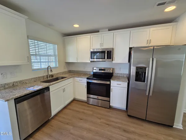 a kitchen with stainless steel appliances a refrigerator sink and microwave