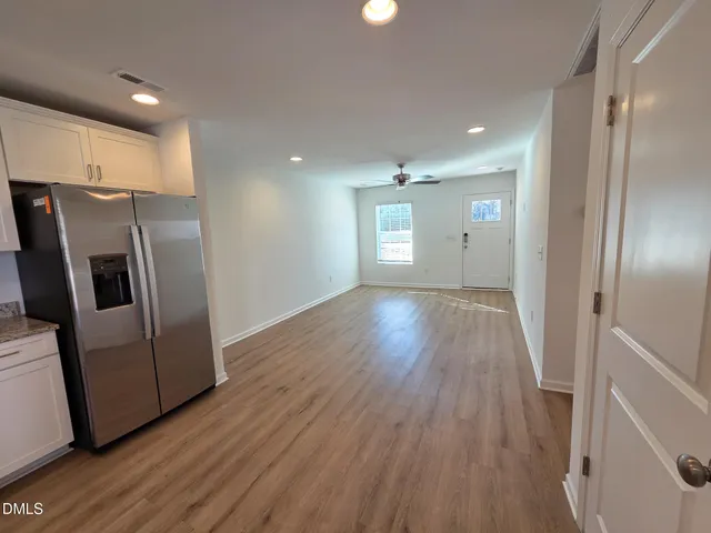 a view of a kitchen with wooden floor and electronic appliances