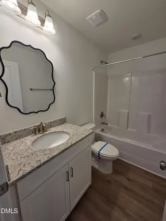 a bathroom with a granite countertop toilet sink and mirror