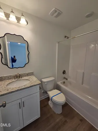 a bathroom with a granite countertop toilet a sink and bathtub