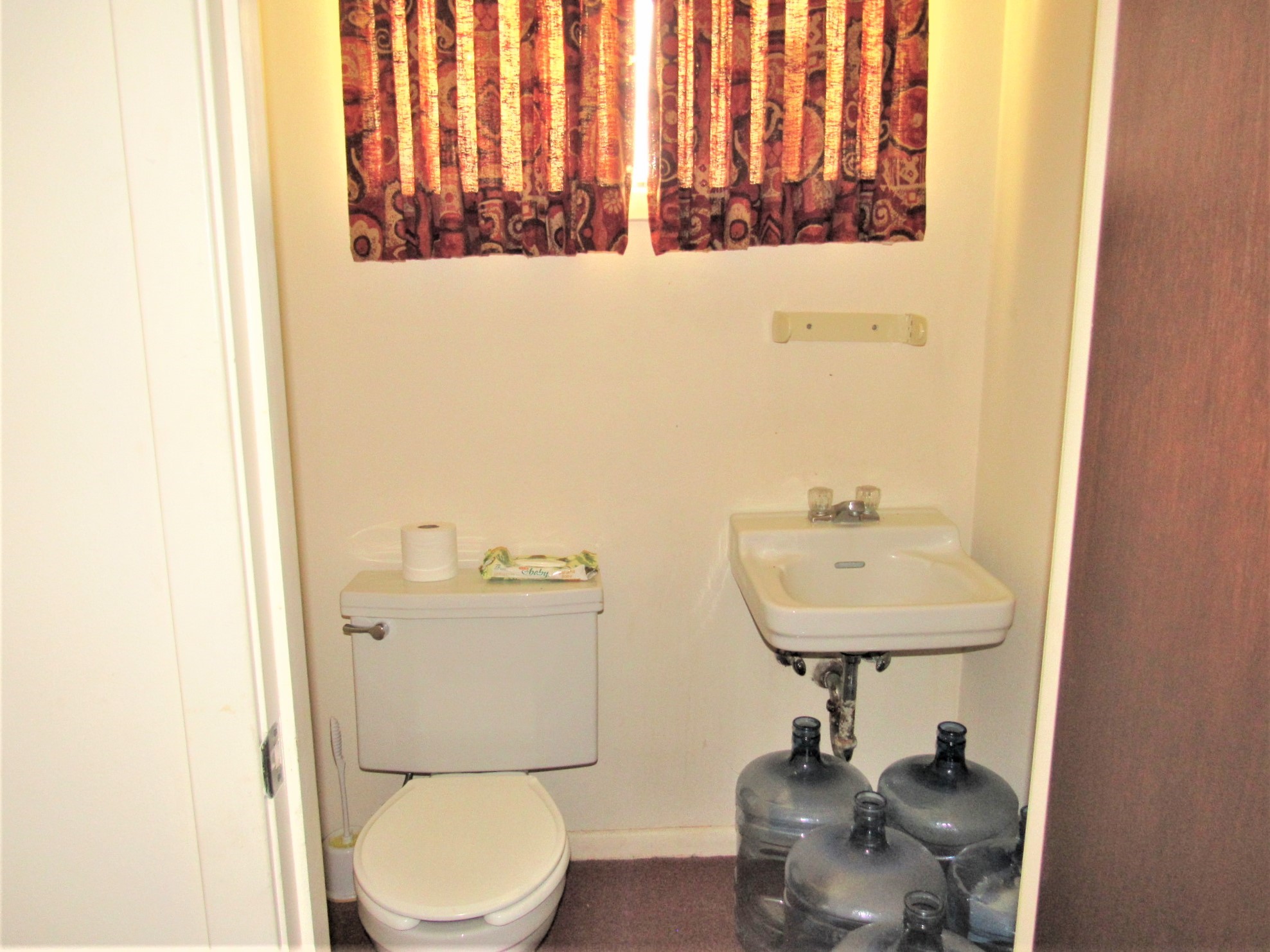 1116 North Fulton Street Wharton, TX 77488 - Photo 24 of 45 a bathroom with a toilet a sink and a mirror