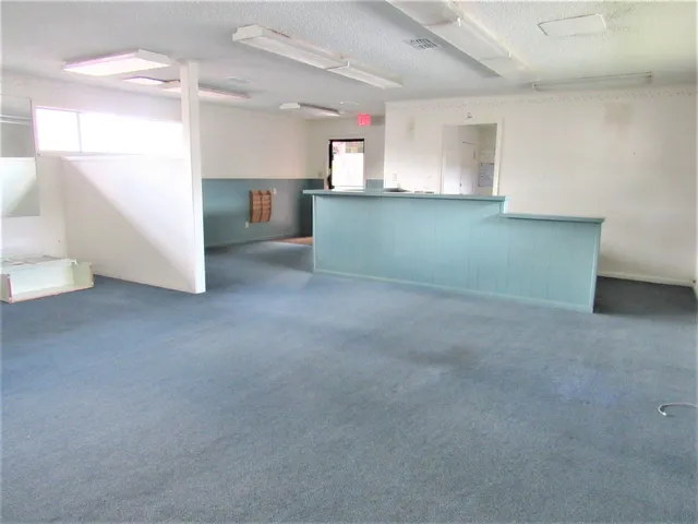 a view of an empty room with window and stairs