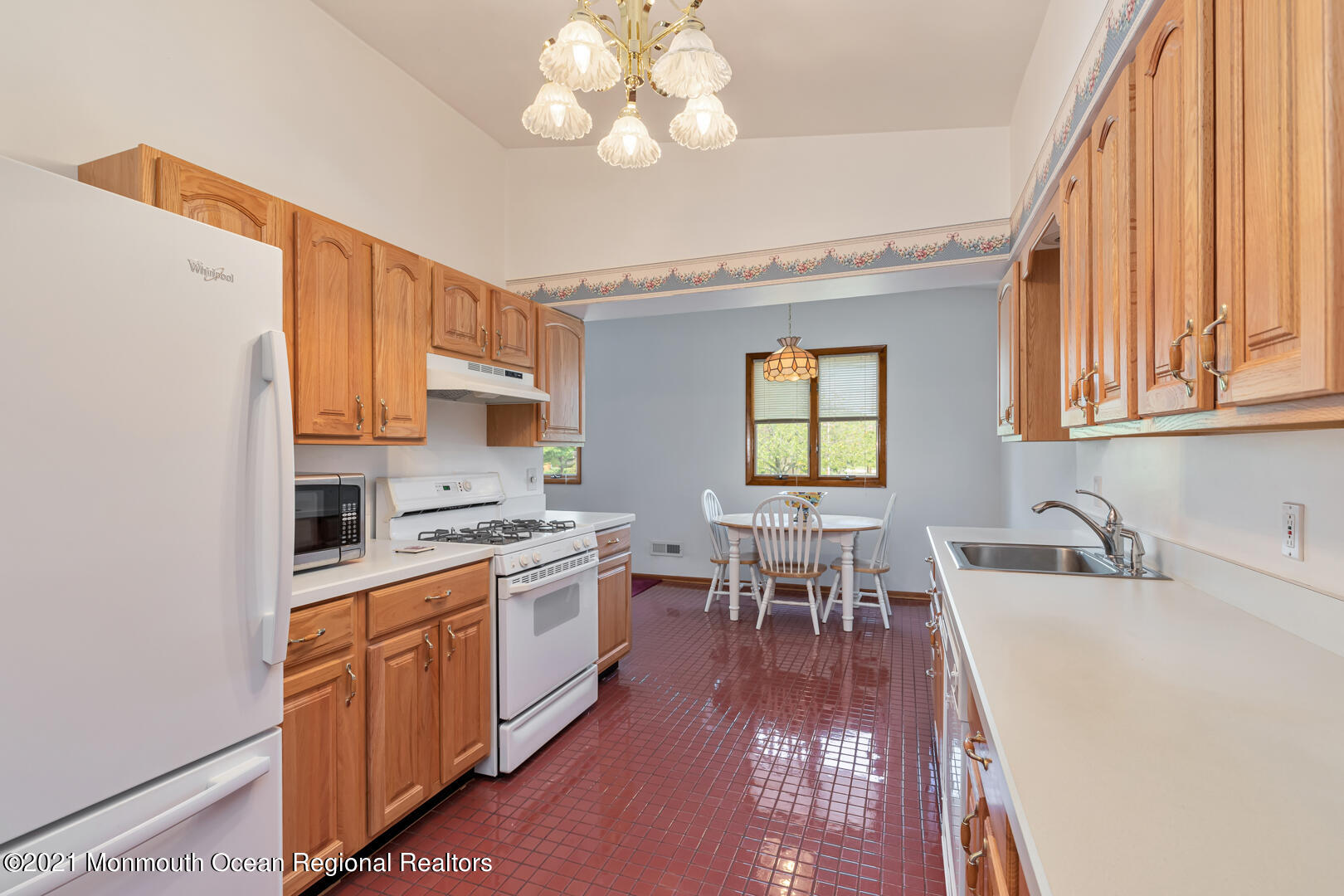 210 Middle Road Hazlet, NJ 07730 - Photo 14 of 30 a kitchen with a dining table chairs sink and cabinets