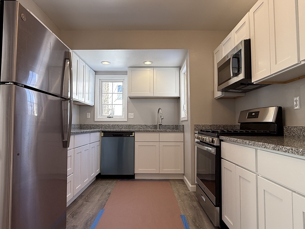 703 Mill Street Marion, MA 02738 - Photo 6 of 20 a kitchen with stainless steel appliances granite countertop a sink stove microwave and refrigerator