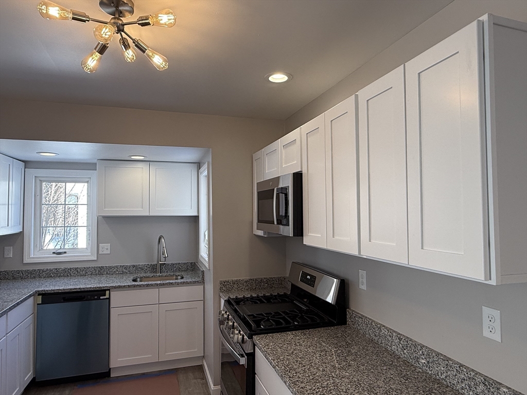 703 Mill Street Marion, MA 02738 - Photo 7 of 20 a kitchen with granite countertop a stove a sink and a refrigerator