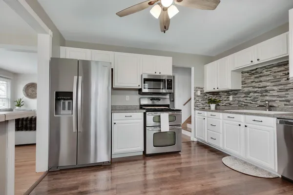 a kitchen with stainless steel appliances a refrigerator sink and microwave