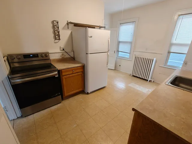 a kitchen with a stove a refrigerator and a fireplace