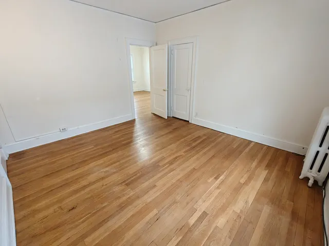 a view of a room with wooden floor and a window