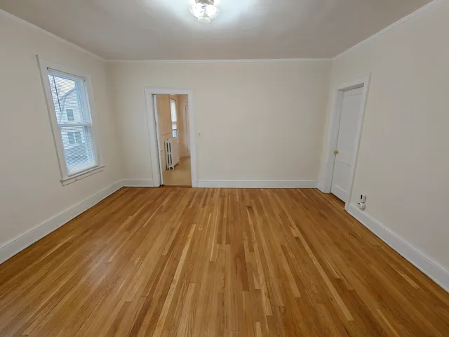 a view of a room with wooden floor and window