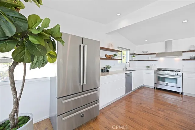 a kitchen with stainless steel appliances a refrigerator and a window