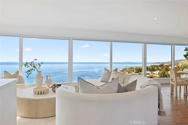 a living room with furniture and floor to ceiling windows