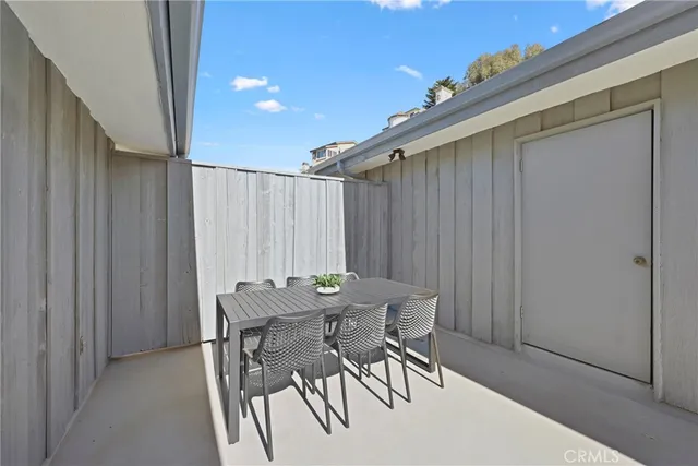 a view of a dinning table and chairs in the balcony