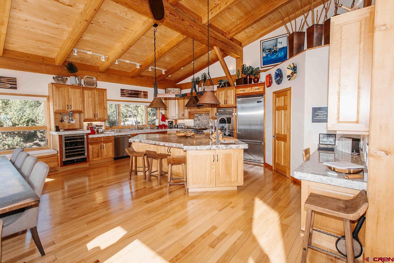 2118 Silverhorn Trail Ridgway, CO 81432 - Photo 15 of 35 a kitchen with stainless steel appliances kitchen island granite countertop a table chairs in it and wooden floors