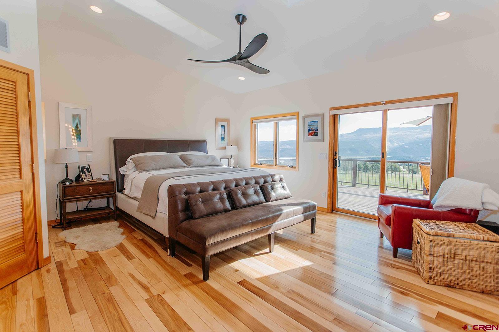 2118 Silverhorn Trail Ridgway, CO 81432 - Photo 22 of 35 a bedroom with a bed wooden floor and windows