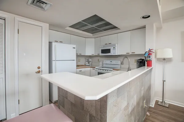 a kitchen with kitchen island a white counter top space cabinets and stainless steel appliances