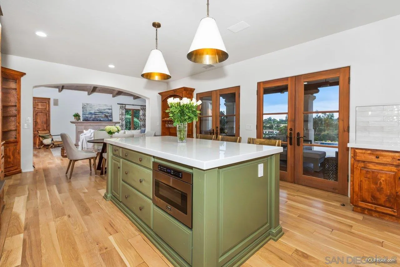5530 Codorniz Rancho Santa Fe, CA 92067 - Photo 12 of 37 a kitchen with stainless steel appliances granite countertop a stove and a wooden floors
