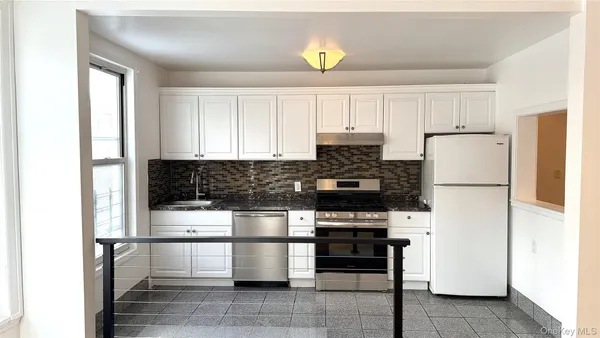 a kitchen with a refrigerator and a stove top oven