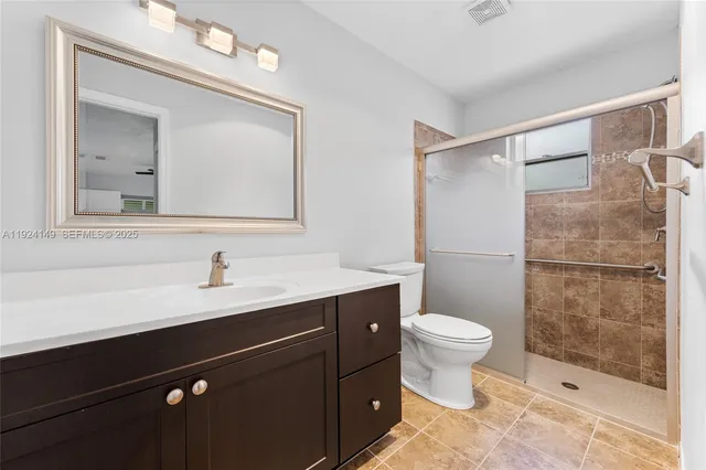 a bathroom with a sink vanity mirror and toilet